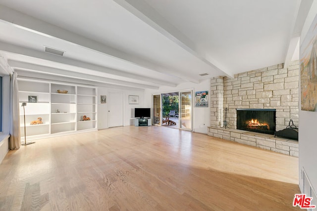 unfurnished living room with a fireplace, beam ceiling, hardwood / wood-style flooring, and built in shelves