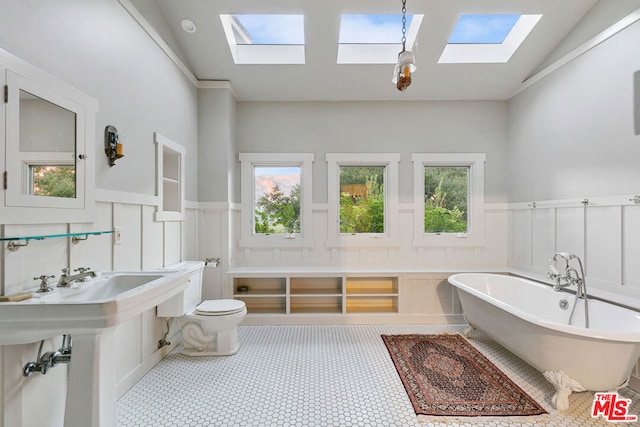 bathroom with vaulted ceiling, toilet, tile patterned floors, and a bath