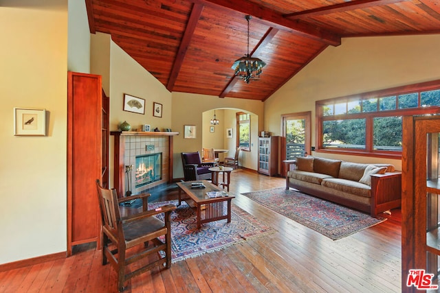 living room with beam ceiling, wood-type flooring, an inviting chandelier, and wooden ceiling