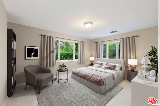 bedroom featuring light carpet and multiple windows