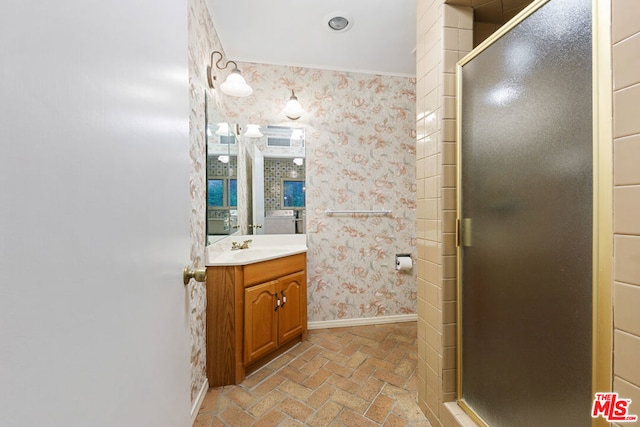 bathroom with an enclosed shower, vanity, and ornamental molding