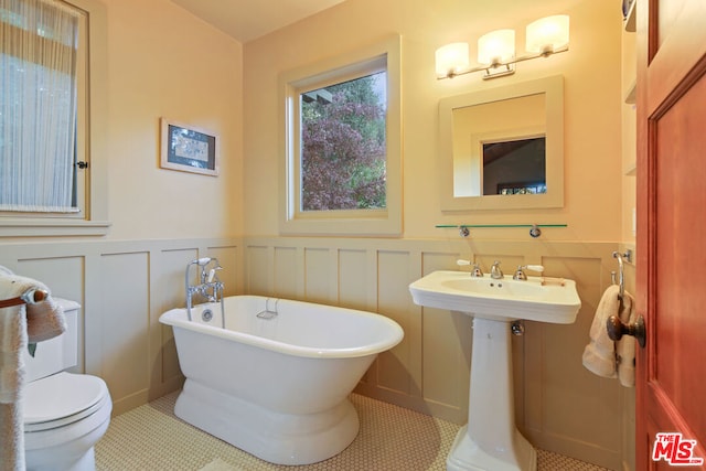 bathroom with toilet, tile patterned flooring, and a washtub