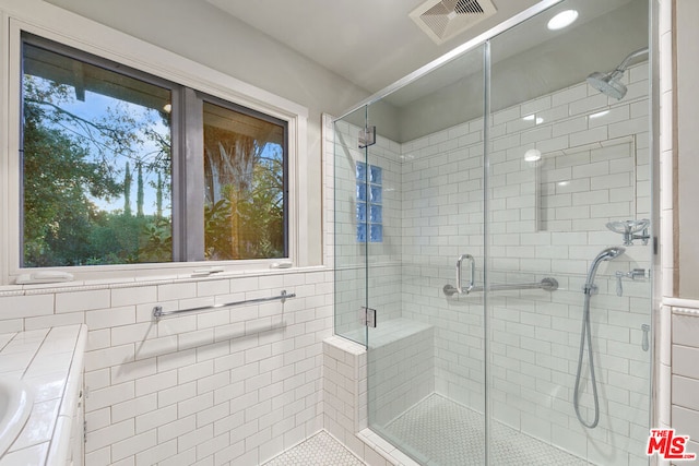 bathroom with vanity, tile walls, and a shower with door