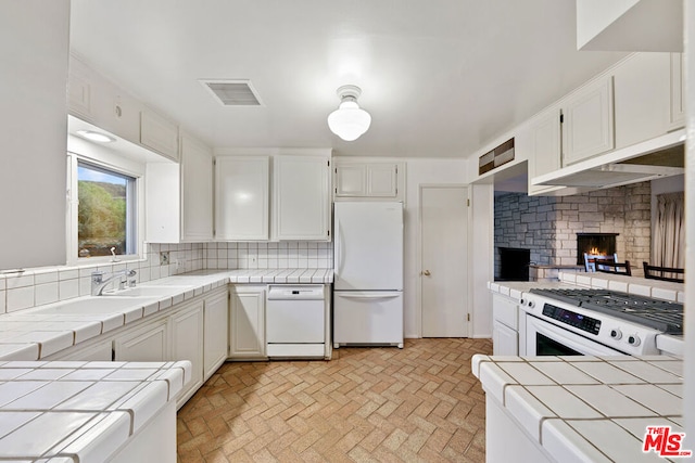 kitchen with tile counters, white cabinetry, tasteful backsplash, and white appliances