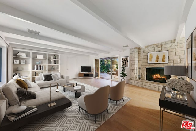 living room featuring a fireplace, beamed ceiling, and light hardwood / wood-style floors