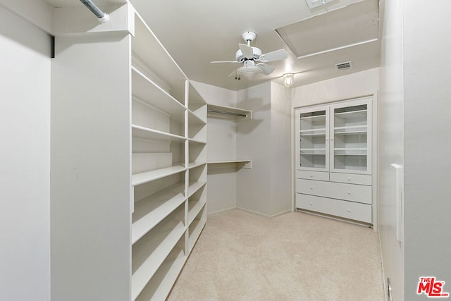 walk in closet featuring ceiling fan and light colored carpet