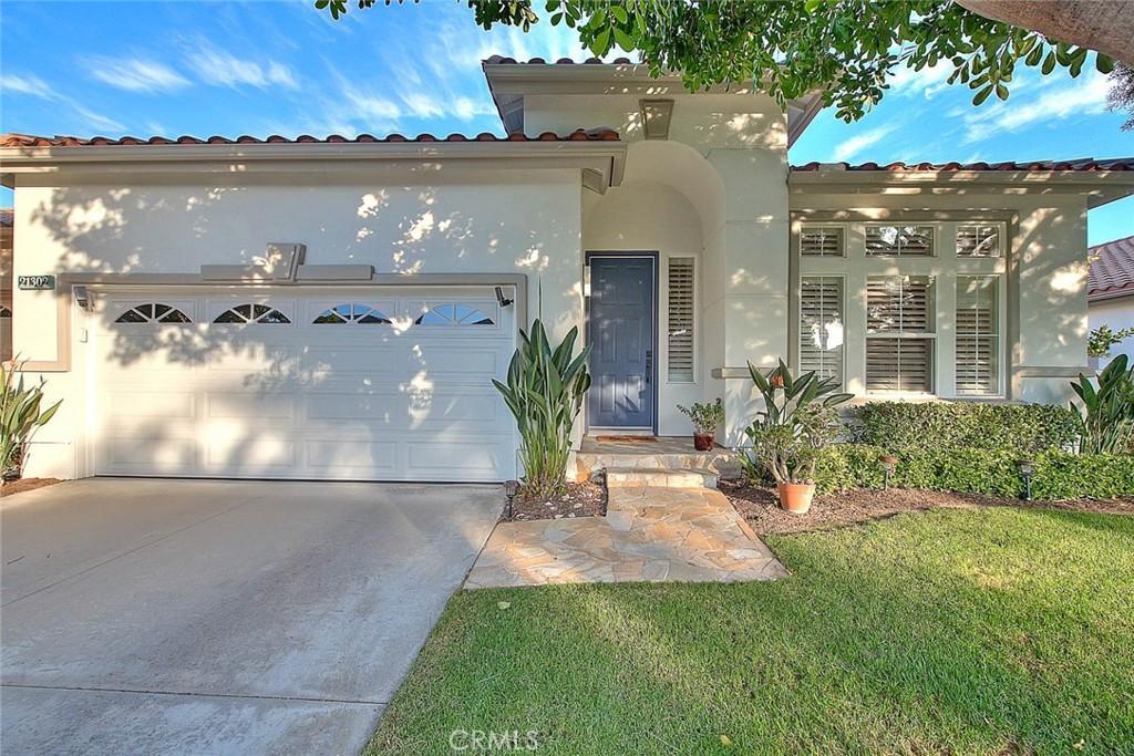 mediterranean / spanish house featuring a front lawn and a garage