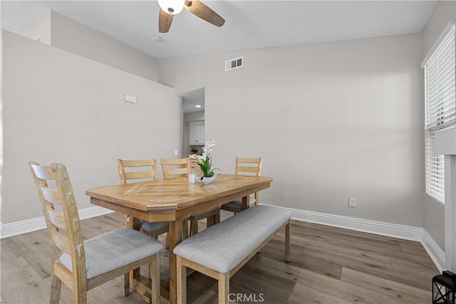 dining space featuring lofted ceiling, wood-type flooring, and plenty of natural light