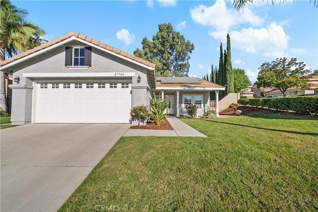 view of front facade featuring a front yard, a garage, and solar panels