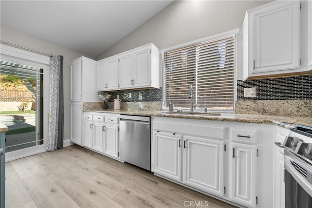 kitchen with sink, white cabinetry, dishwasher, and lofted ceiling