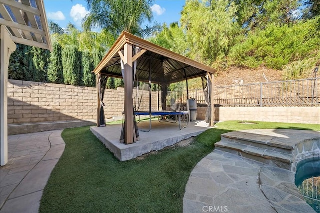 view of community featuring a patio area, a gazebo, and a trampoline