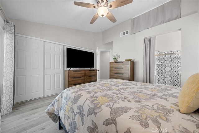 bedroom featuring ceiling fan, lofted ceiling, a closet, and light hardwood / wood-style floors