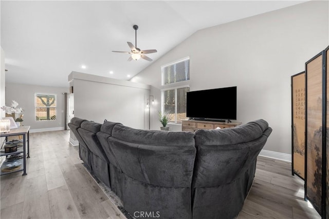 living room featuring vaulted ceiling, ceiling fan, and light wood-type flooring