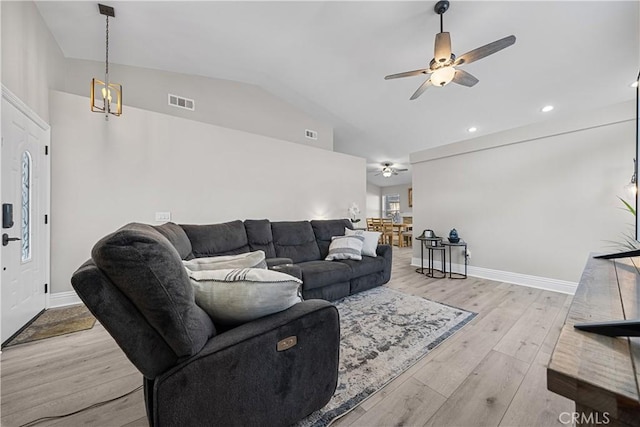 living room with ceiling fan, vaulted ceiling, and light hardwood / wood-style flooring