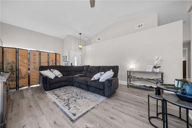 living room with light hardwood / wood-style flooring and high vaulted ceiling