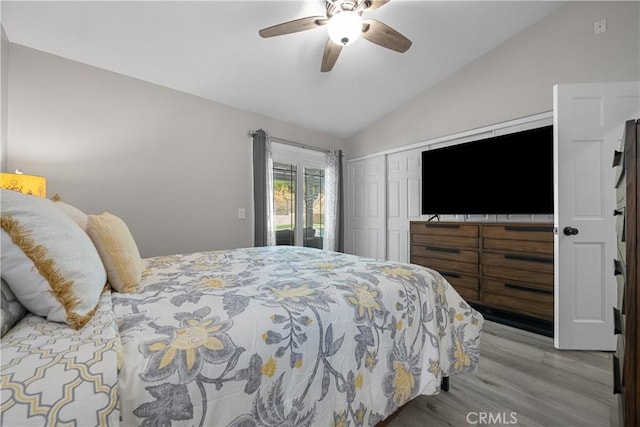 bedroom featuring ceiling fan, light hardwood / wood-style flooring, a closet, and vaulted ceiling