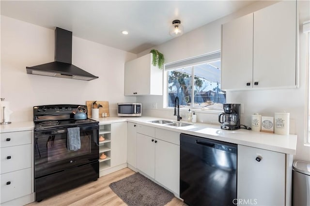 kitchen featuring black appliances, sink, white cabinetry, light wood-type flooring, and wall chimney exhaust hood