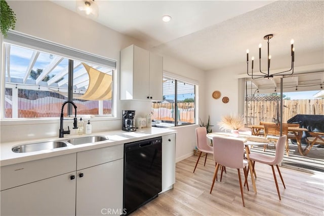 kitchen featuring a notable chandelier, light wood-type flooring, dishwasher, white cabinets, and sink