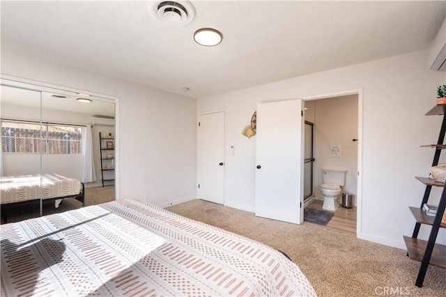 bedroom featuring connected bathroom, a closet, and carpet