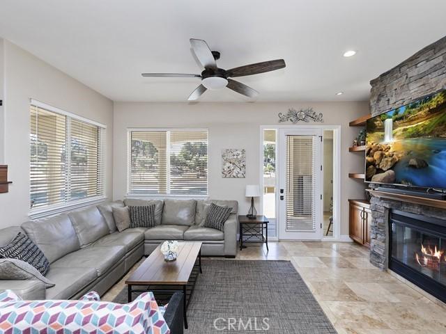 living area with recessed lighting, a fireplace, and a ceiling fan