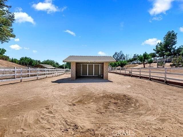 view of horse barn featuring a rural view