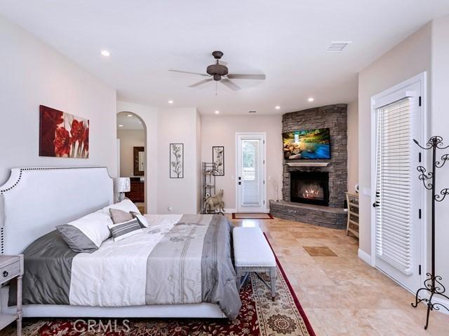 bedroom with a ceiling fan, recessed lighting, a fireplace, and arched walkways