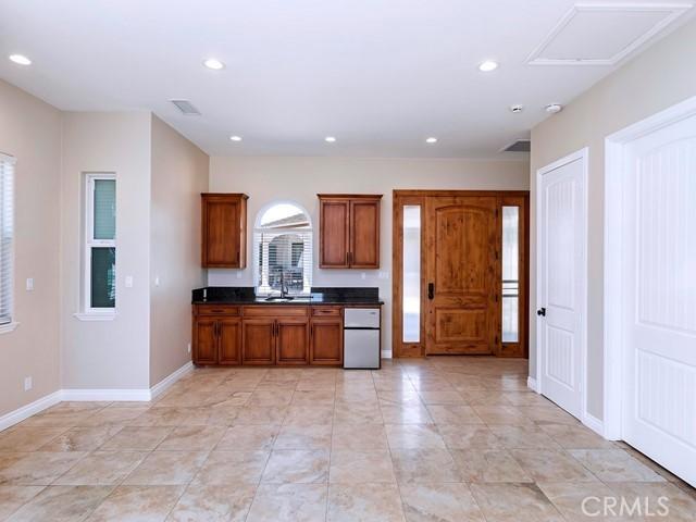 kitchen featuring dark countertops, recessed lighting, brown cabinetry, and freestanding refrigerator