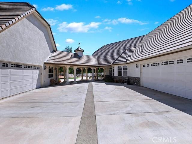 exterior space with stone siding, stucco siding, driveway, and an attached garage