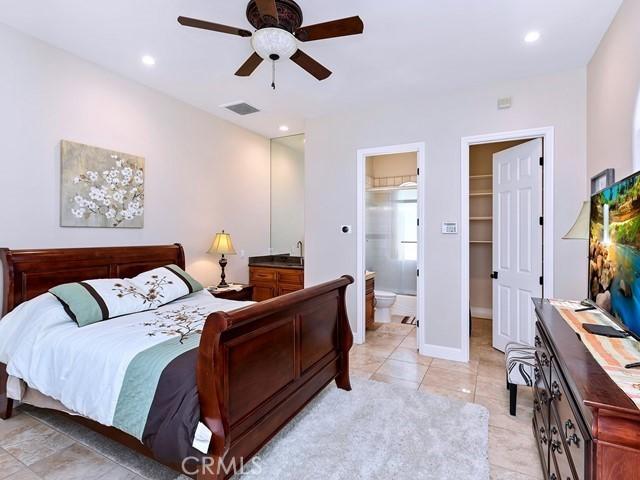 bedroom with a spacious closet, light tile patterned flooring, recessed lighting, and visible vents