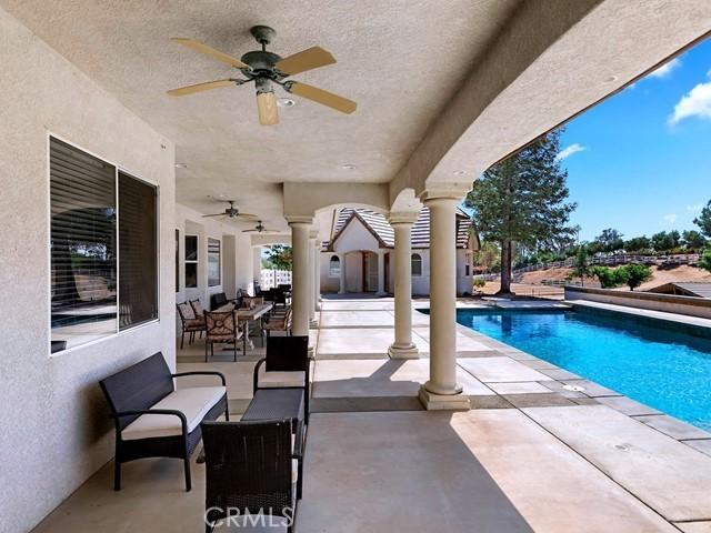 pool with outdoor dining space, a ceiling fan, outdoor lounge area, and a patio