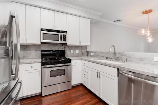 kitchen featuring appliances with stainless steel finishes, white cabinets, light stone counters, and sink