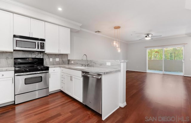 kitchen with appliances with stainless steel finishes, white cabinetry, sink, hanging light fixtures, and kitchen peninsula