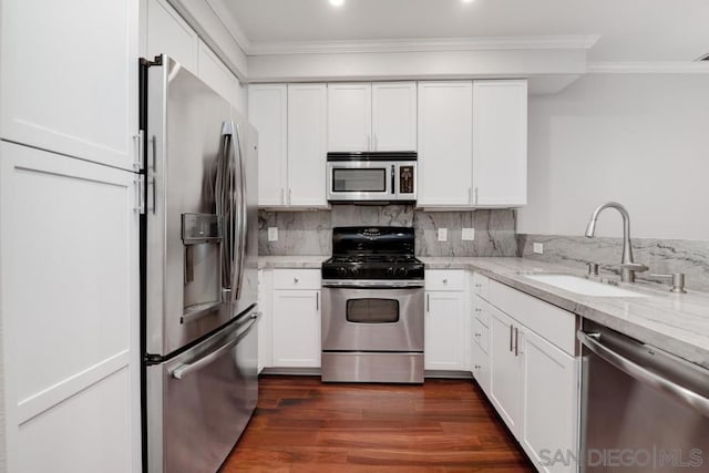 kitchen featuring sink, white cabinetry, dark wood-type flooring, appliances with stainless steel finishes, and light stone counters