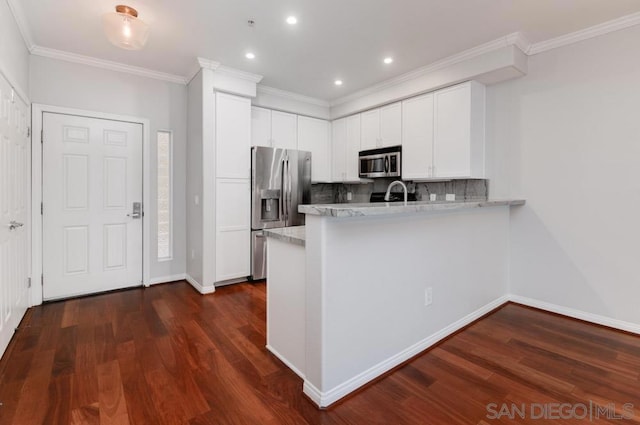 kitchen featuring stainless steel appliances, decorative backsplash, dark hardwood / wood-style flooring, and white cabinets