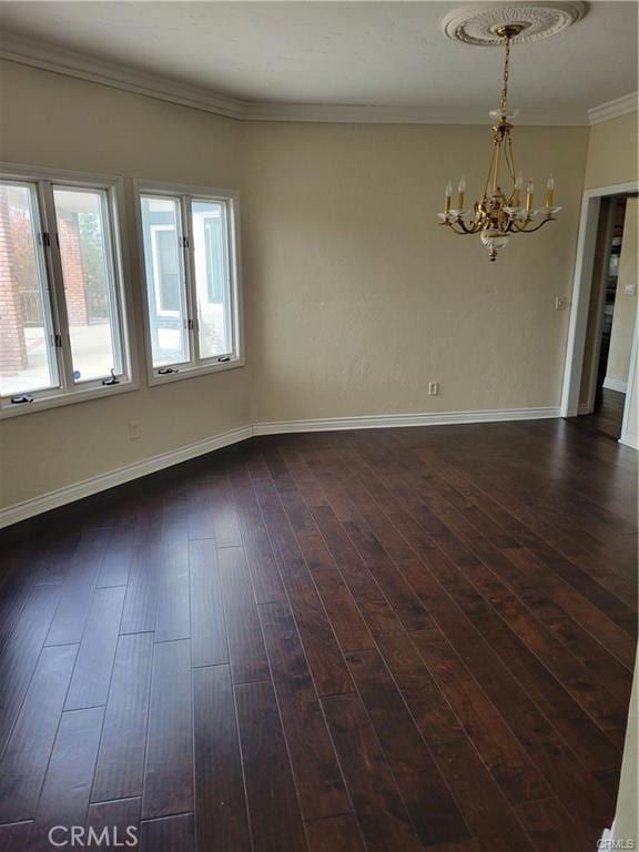 unfurnished room featuring dark wood-type flooring, an inviting chandelier, and ornamental molding