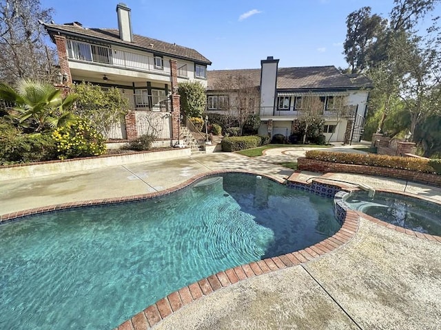 view of pool featuring a patio and an in ground hot tub