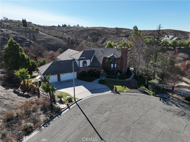 6966 Ranch View Rd, Riverside, CA 92506 - view of front facade featuring driveway, a chimney, a garage, and a mountain view
