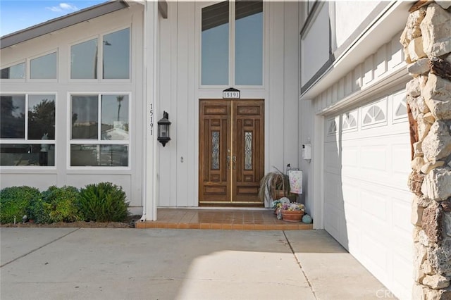 view of exterior entry with a garage and french doors