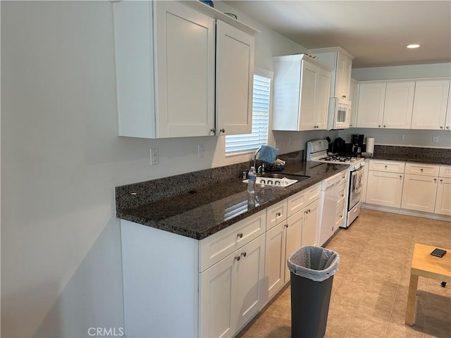 kitchen with sink, white cabinets, and white appliances