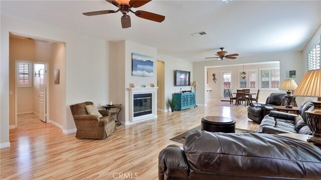 living room featuring ceiling fan and light hardwood / wood-style flooring