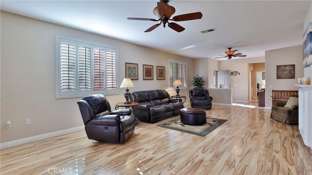 living room with ceiling fan and light hardwood / wood-style flooring