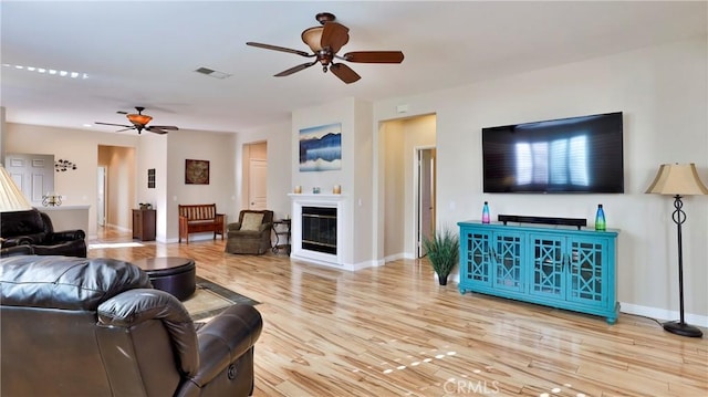 living room featuring ceiling fan and light hardwood / wood-style flooring