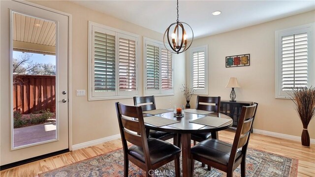 dining room with a wealth of natural light, light hardwood / wood-style flooring, and a notable chandelier