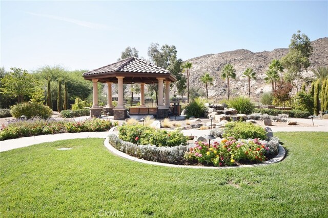 view of community with a lawn, a gazebo, and a mountain view