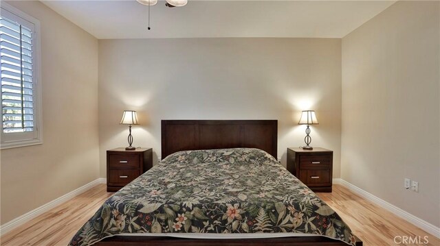 bedroom with multiple windows and light wood-type flooring