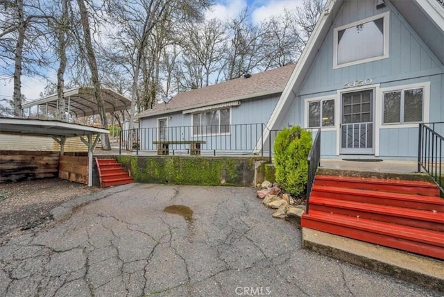 back of house featuring a carport