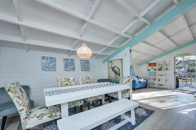 interior space with vaulted ceiling, wood walls, and hardwood / wood-style floors