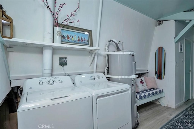 washroom with washer and dryer, strapped water heater, and light hardwood / wood-style floors