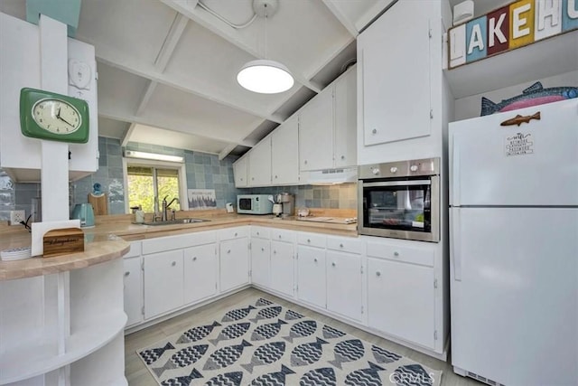 kitchen with light hardwood / wood-style floors, backsplash, white appliances, white cabinets, and sink