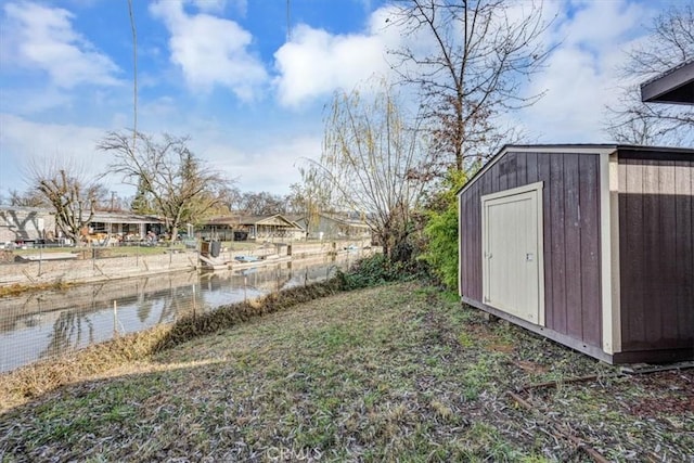 view of yard with a water view and a storage unit